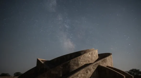 Silhouette d'un observatoire astronomique ancien type Jantar Mantar sous un ciel étoilé dense et réaliste, évoquant la précision du Jyotish.